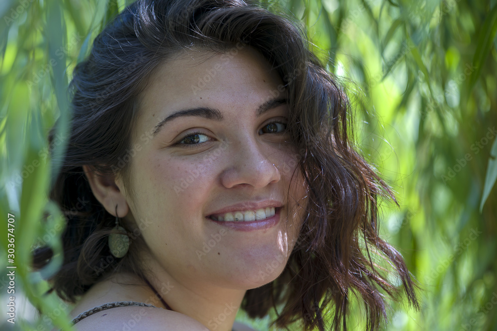 Portrait of a woman under a willow tree with green leaves Portrait of a woman under a willow tree with green leaves