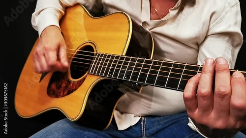 Man expressive plays acoustic guitar. Close-up view.