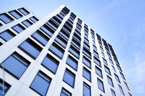 Modern European building. White building with many windows against the blue sky. Abstract architecture  fragment of modern urban geometry.