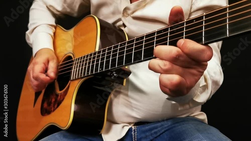 Man expressive plays acoustic guitar. Close-up view.