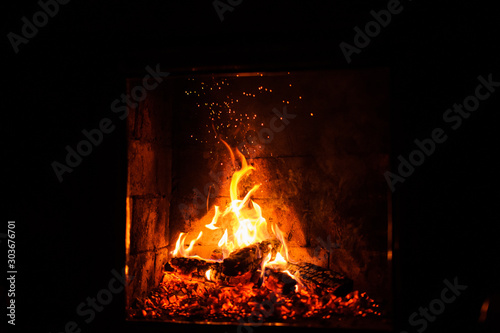 A fire burns in a fireplace, close up shot of burning firewood in the fireplace