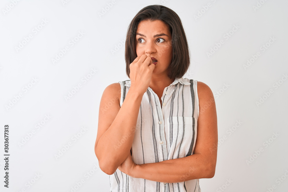 Young beautiful woman wearing casual striped shirt standing over isolated white background looking stressed and nervous with hands on mouth biting nails. Anxiety problem. Young beautiful woman wearing casual striped shirt standing over isolated white background looking stressed and nervous with hands on mouth biting nails. Anxiety problem.