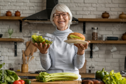 Senior woman making choice between healthy and junk food