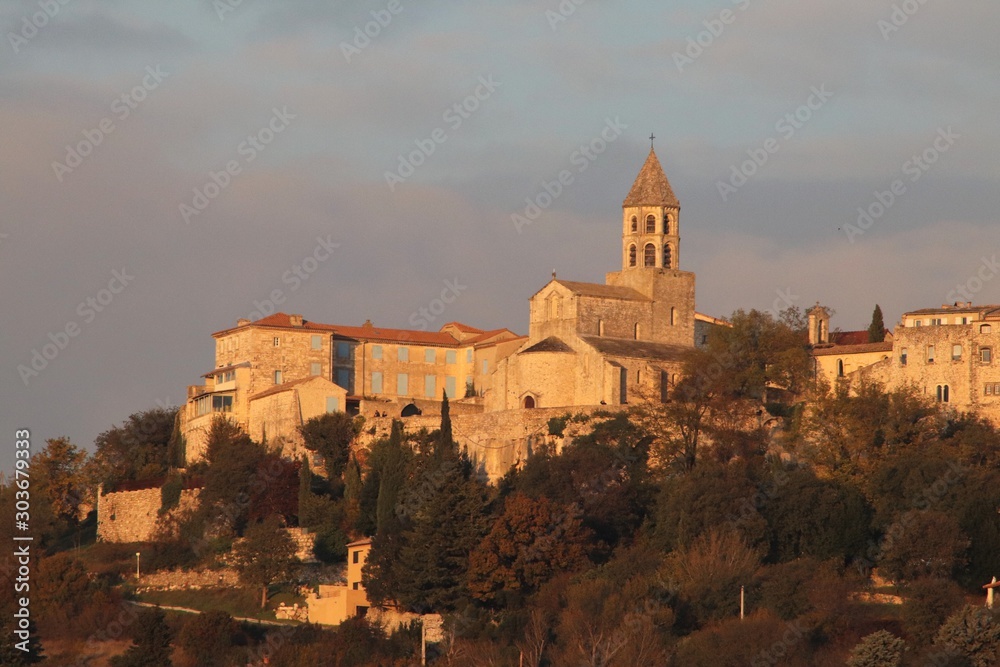 Fototapeta premium La Garde Adhémar - Village typique de la Drôme provençale vu depuis la route en contrebas au soleil couchant