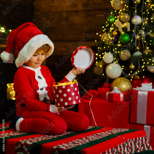 Merry and bright christmas. Lovely baby enjoy christmas. Childhood memories. Santa boy little child celebrate christmas at home. Family holiday. Boy cute child cheerful mood play near christmas tree