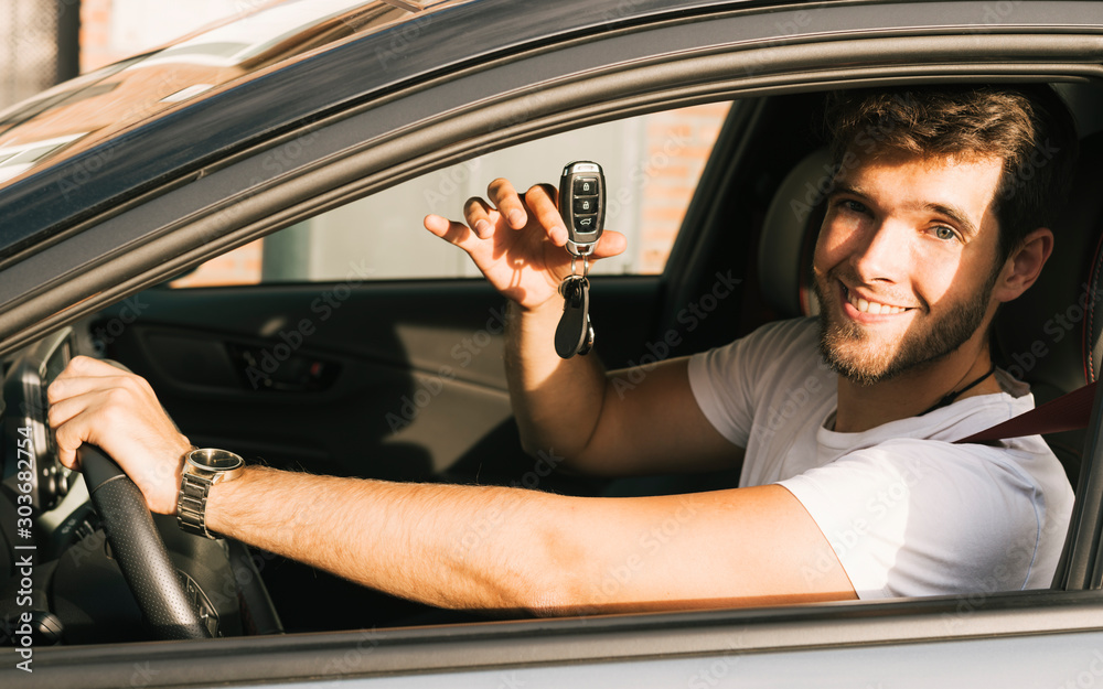 Ταπετσαρία Attractive young man with a beard teaches the camera the keys of his new car