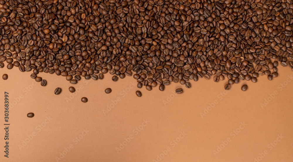 Dark brown whole coffee beans on wood background with copyspace Dark brown whole coffee beans on wood background with copyspace