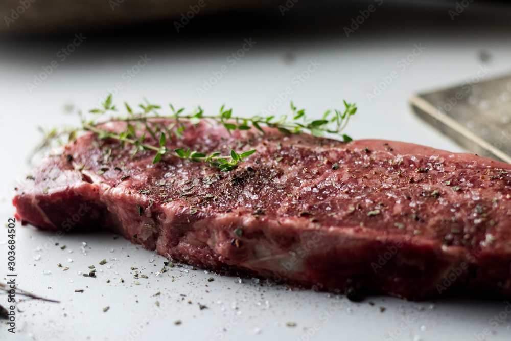 Close up Raw Steak Meat with salt and herbs on marble Close up Raw Steak Meat with salt and herbs on marble