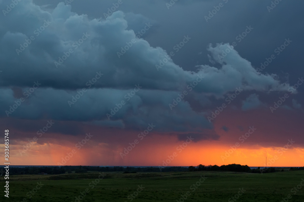 storm clouds over the field at sunset