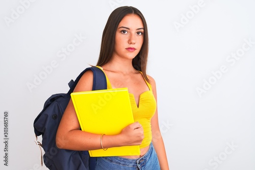 Beautiful student girl wearing backpack holding notebook over isolated white background with a confident expression on smart face thinking serious