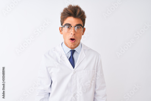 Young handsome sciencist man wearing glasses and coat over isolated white background In shock face, looking skeptical and sarcastic, surprised with open mouth