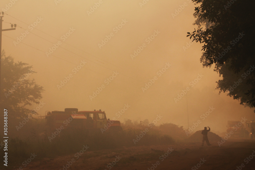 Fototapeta premium fire in a garbage dump, smoke and waste