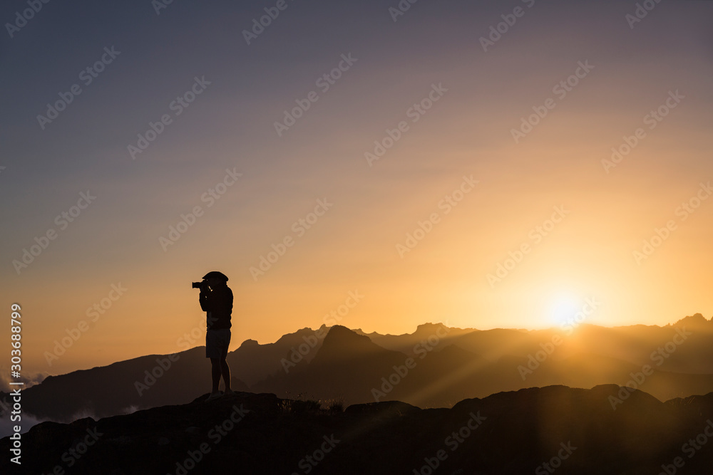 silhouette of man on top of mountain at sunset
