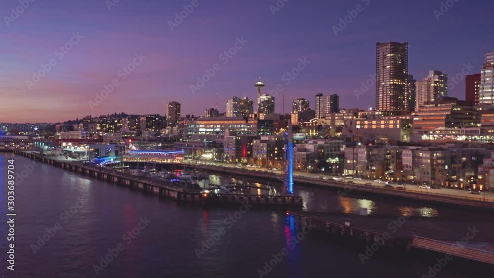 Aerial: Flying over the Seattle city skyline, Alaskan Way and Elliott Bay waterfront at night. Washington, USA Aerial: Flying over the Seattle city skyline, Alaskan Way and Elliott Bay waterfront at night. Washington, USA