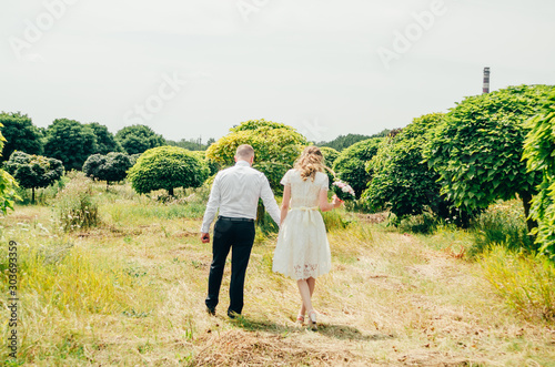 couple walking between the trees
