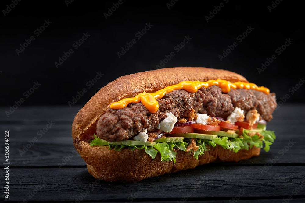 close up of kebab sandwich on black wooden background close up of kebab sandwich on black wooden background
