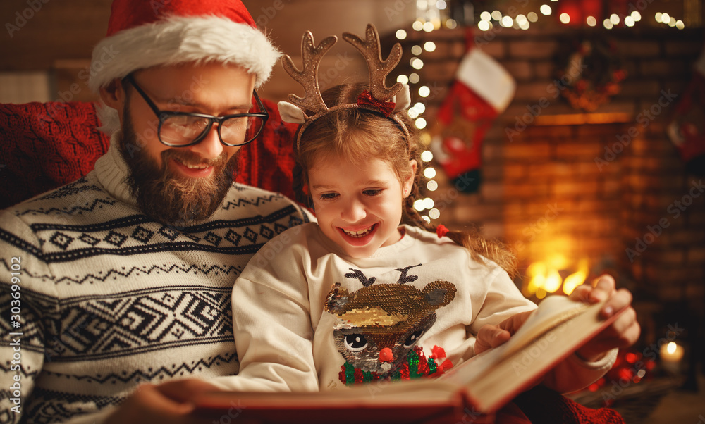 Christmas Eve. family father and child reading magic book at home . - obrazy, fototapety, plakaty 