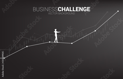Silhouette of businessman walking on rope walk way up to growth line graph.Concept for business risk and challenge in career path