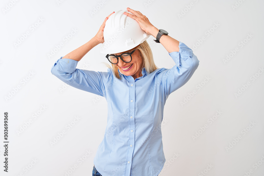 Middle age architect woman wearing glasses and helmet over isolated white background suffering from headache desperate and stressed because pain and migraine. Hands on head. Middle age architect woman wearing glasses and helmet over isolated white background suffering from headache desperate and stressed because pain and migraine. Hands on head.