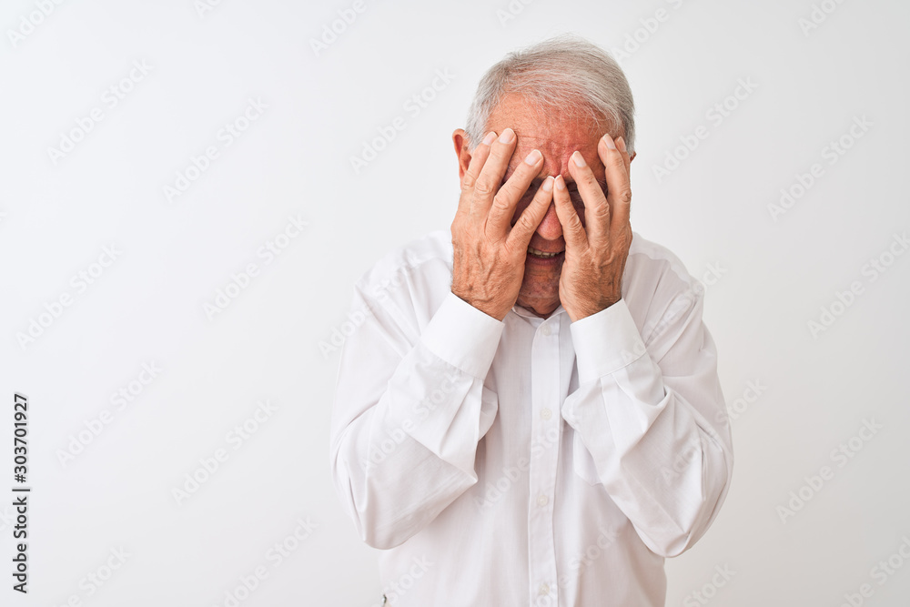 Senior grey-haired man wearing elegant shirt standing over isolated white background with sad expression covering face with hands while crying. Depression concept. Senior grey-haired man wearing elegant shirt standing over isolated white background with sad expression covering face with hands while crying. Depression concept.