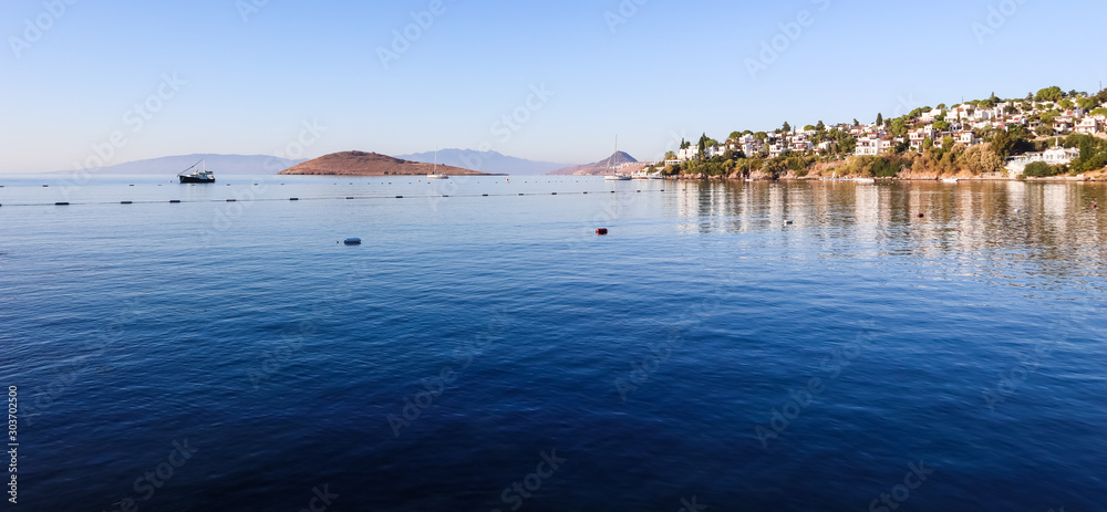 Aegean coast with marvelous blue water, islands, mountains and small white houses