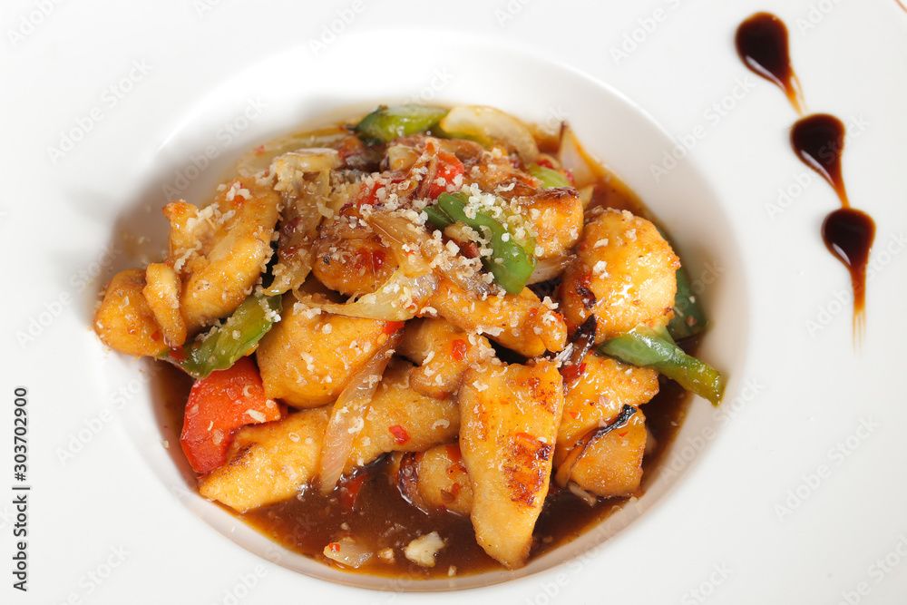 Potatoes with vegetables and sauceon plate close-up