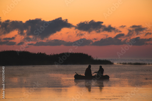 fishermen in a boat at dawn, bright colors