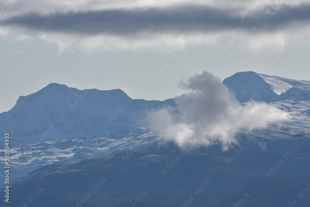 View of the Sierra Nevada with rising clouds, one autumn morning after the snowfall of the night