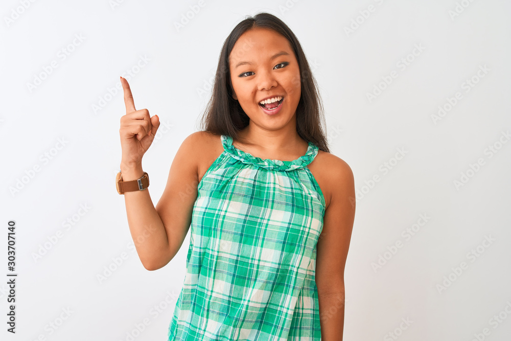 Young chinese woman wearing green dress standing over isolated white background pointing finger up with successful idea. Exited and happy. Number one. Young chinese woman wearing green dress standing over isolated white background pointing finger up with successful idea. Exited and happy. Number one.