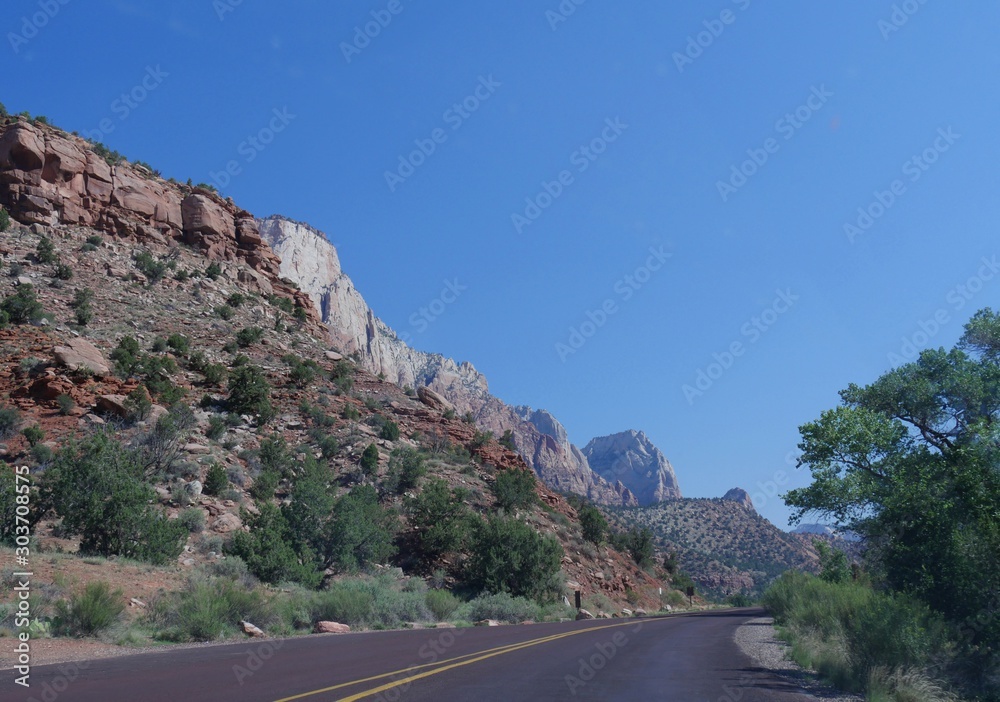 Paved road along steep mountains and cliffs at Zion National Park in Utah, USA.