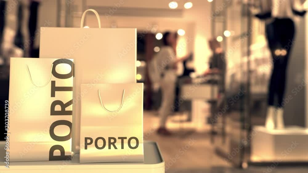 Paper shopping bags with Porto caption against blurred store entrance. Retail in Portugal related 3D animation Paper shopping bags with Porto caption against blurred store entrance. Retail in Portugal related 3D animation