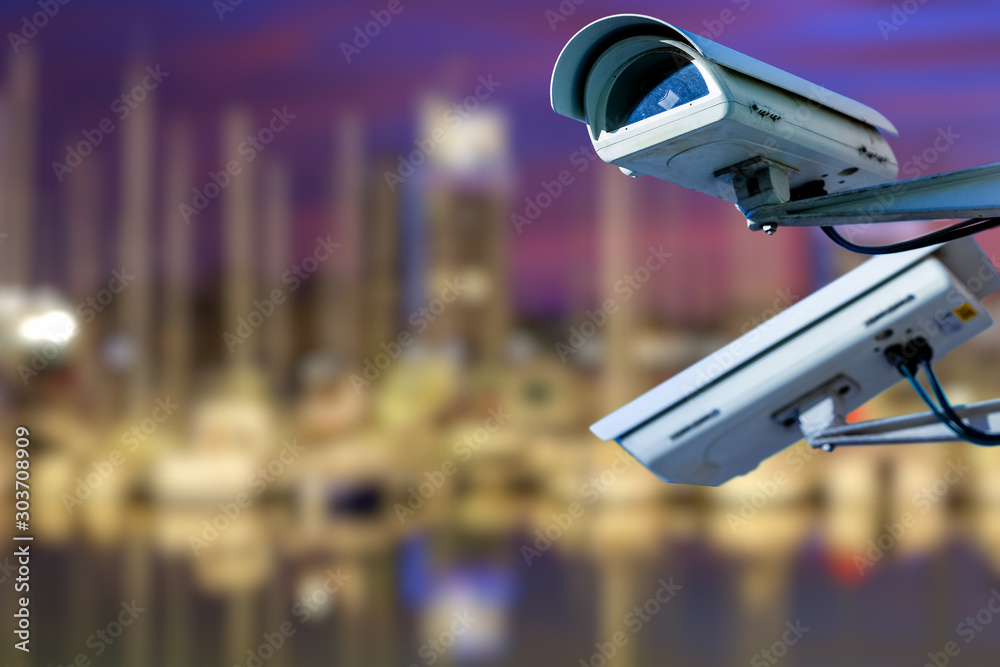 CCTV camera concept with illuminated marina on background