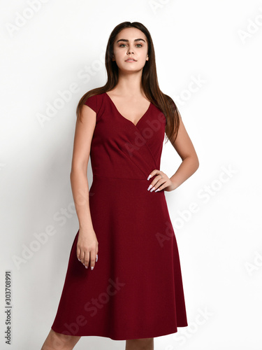 Young beautiful woman posing in new fashion casual red winter dress happy smiling walking on white full body