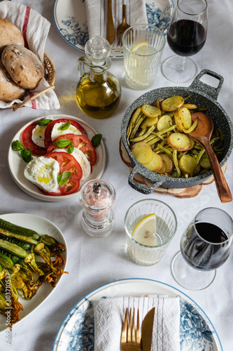 Mediterranean cuisine, served dinner, burrata cheese, olive oil, tomato, stuffed potato, zucchini and red wine