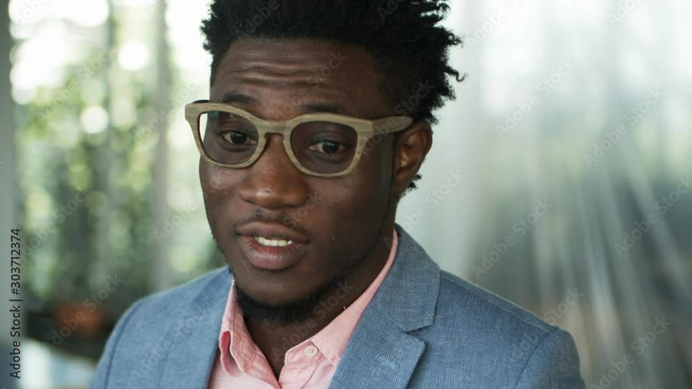 Handsome young man talking. Closeup shot of young guy in eyeglasses speaking to someone. Public speaking concept Handsome young man talking. Closeup shot of young guy in eyeglasses speaking to someone. Public speaking concept