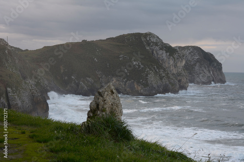 Waves beating against the rocks at Vidiago beach in Asturias photo