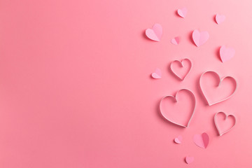 Composition for Valentine's Day February 14th. Delicate pink background and pink hearts cut out of paper. Greeting card. Flat lay, top view, copy space.