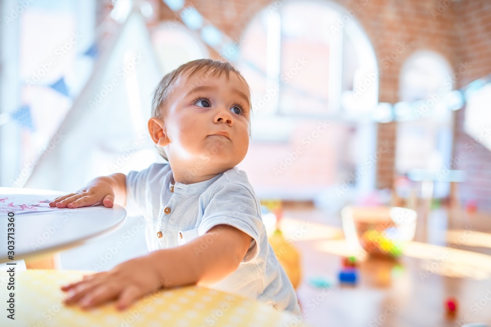 Adorable toddler standing around lots of toys at kindergarten Adorable toddler standing around lots of toys at kindergarten