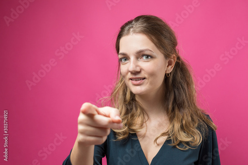 Happy young caucasian female pointing fingers away, showing copy space for your text. 