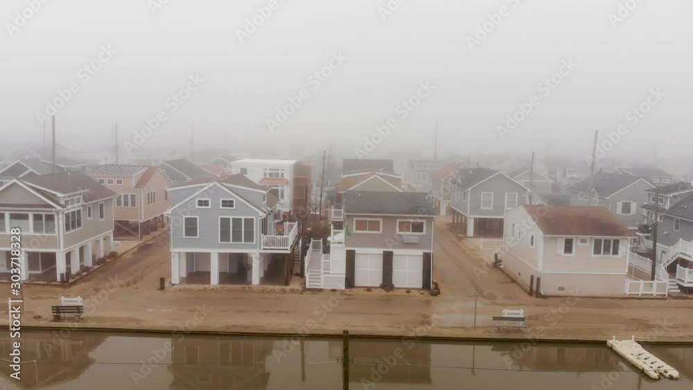 Aerial flying through a tightly packed beach town on a foggy wet day. Aerial flying through a tightly packed beach town on a foggy wet day.