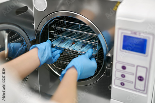 Dentist is loading dental probes into sterilize machine photo