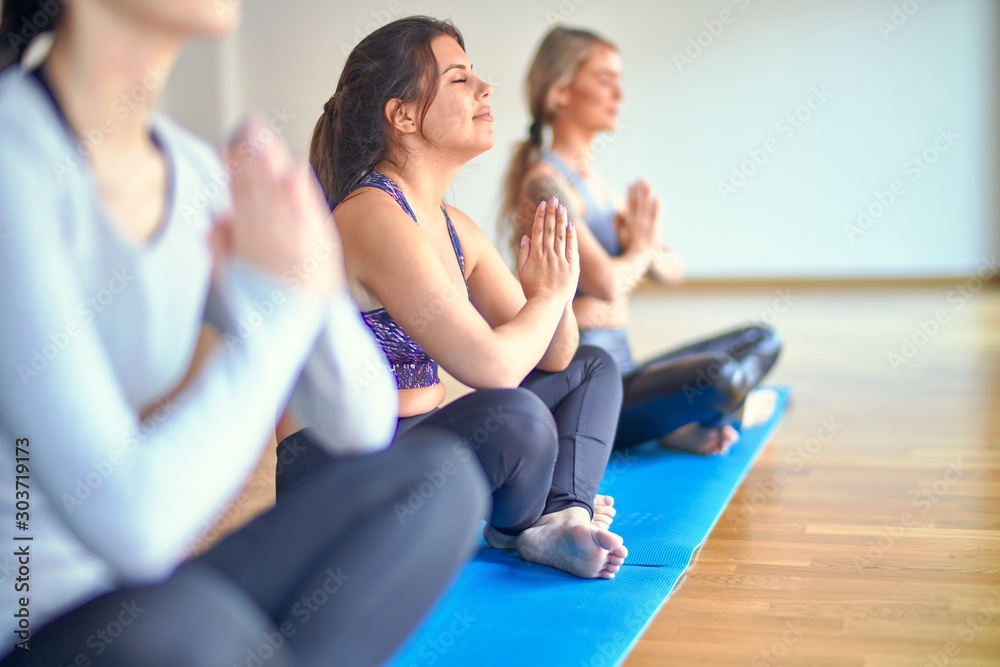 Young beautiful group of sportswomen practicing yoga at gym Young beautiful group of sportswomen practicing yoga at gym