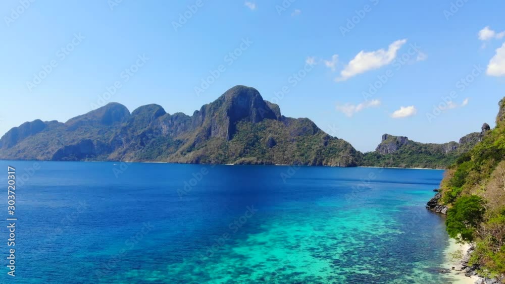 Aerial drone shot abovePhilippine coastline with sand beach and blue ocean during sunset Aerial drone shot abovePhilippine coastline with sand beach and blue ocean during sunset