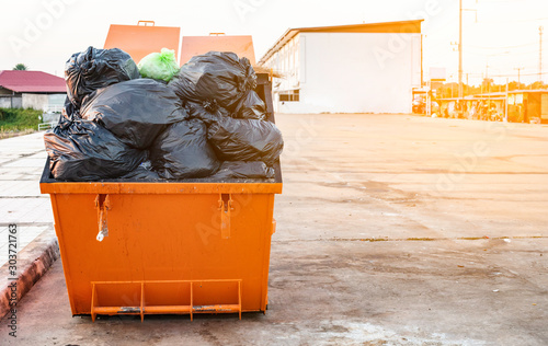 Trash is made of large colored steel with many garbage bags.