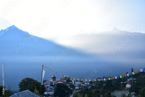 インドのヒマラヤ山岳地帯　キナウル谷のレコンピオのカルパ村　美しい朝日と山と街並み　チベット仏教寺院と旗 photo