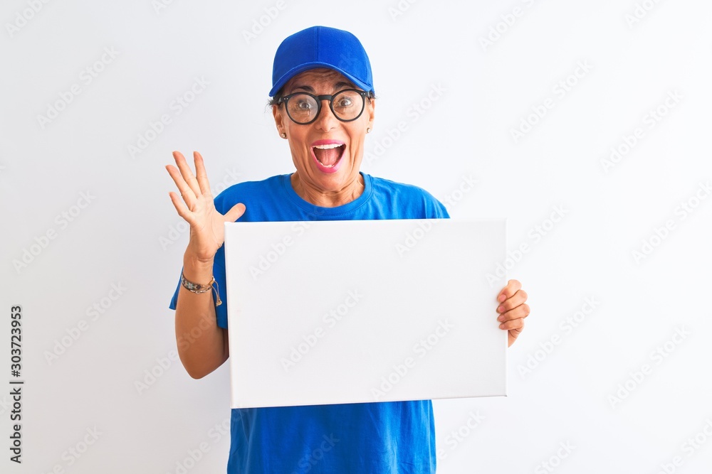 Senior deliverywoman wearing cap and glasses holding banner over isolated white background very happy and excited, winner expression celebrating victory screaming with big smile and raised hands Senior deliverywoman wearing cap and glasses holding banner over isolated white background very happy and excited, winner expression celebrating victory screaming with big smile and raised hands
