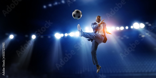 Soccer businessman in action with ball. Mixed media © Sergey Nivens