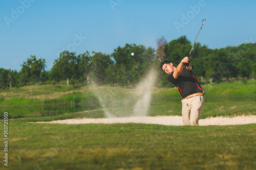 Asian pro golf player amazing shot ball from sand bunker at golf course in summer vacation. Sport, golfer concept.