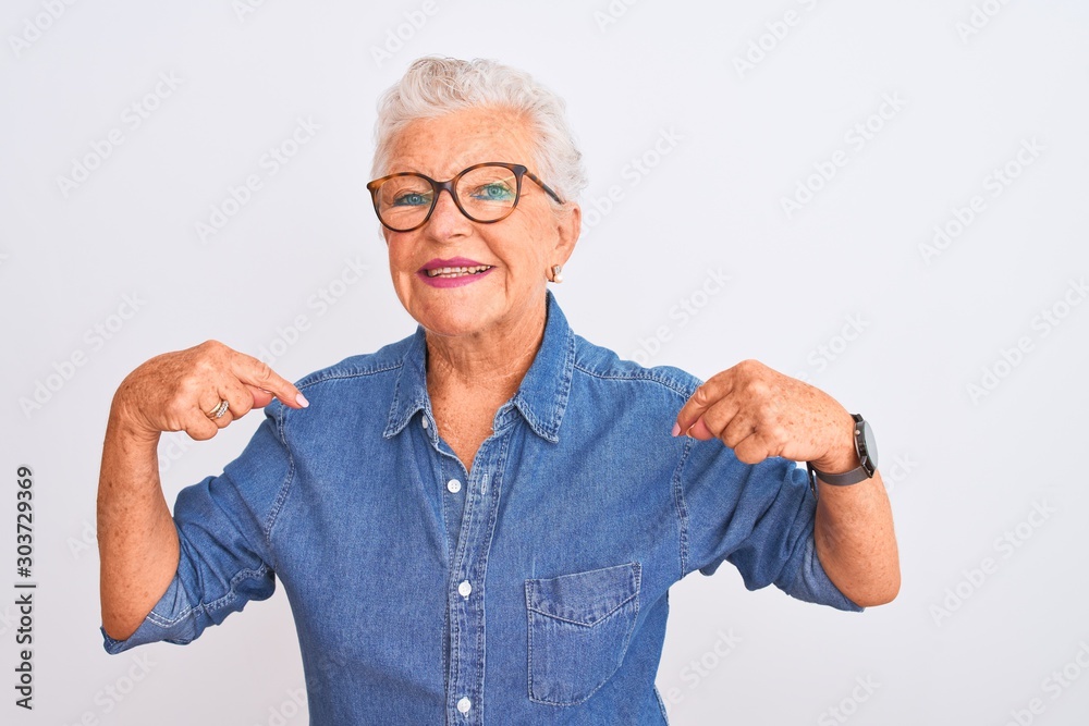 Senior grey-haired woman wearing denim shirt and glasses over isolated white background looking confident with smile on face, pointing oneself with fingers proud and happy. Senior grey-haired woman wearing denim shirt and glasses over isolated white background looking confident with smile on face, pointing oneself with fingers proud and happy.