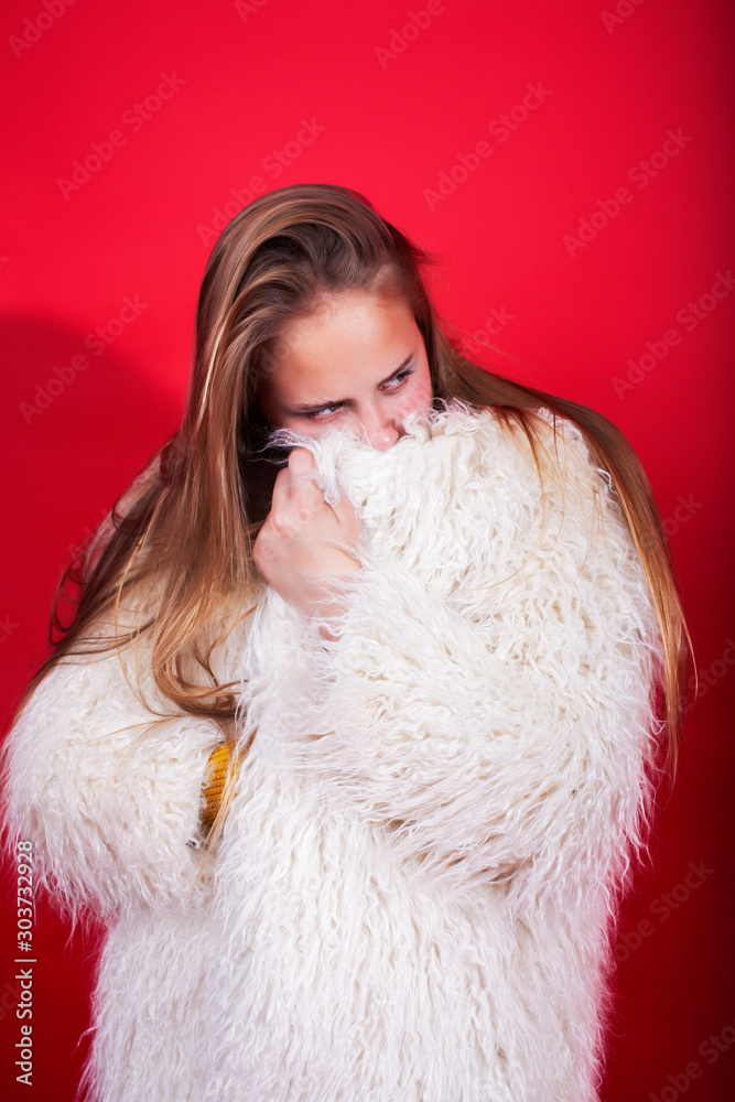 young pretty emitonal posing teenage girl on bright red background, happy smiling lifestyle people concept